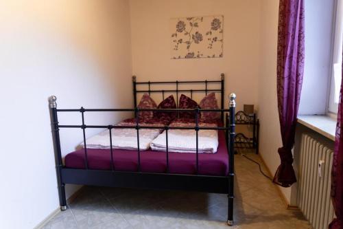 a bedroom with a metal bed with purple sheets at NEU! Reiterhof Finkenmühle Fewo Dolly in Weißenstadt