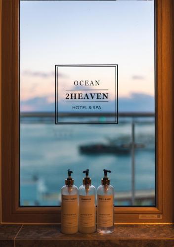 three bottles of soap sitting in front of a window at Nampo Ocean2Heaven Hotel& Spa in Busan