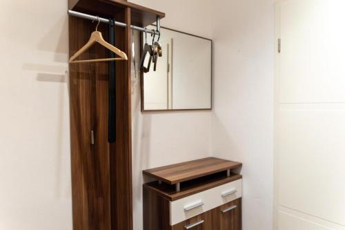 ein Badezimmer mit einem Holzschrank und einem Spiegel in der Unterkunft NEU! Reiterhof Finkenmühle Fewo Sancho mit Kamin in Weißenstadt