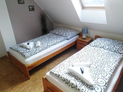 two twin beds in a room with a window at Penzion U dvojice in Nové Město na Moravě