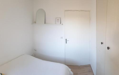 a white room with a bed and a glass door at Appartement T3 50m² - 6 pers. - Barcelonnette in Barcelonnette