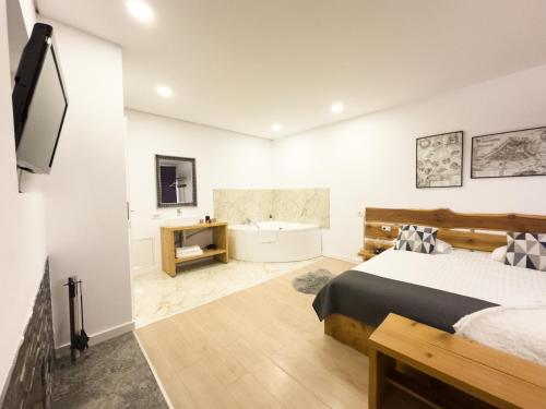 1 dormitorio con cama, bañera y TV en MiddleHouse en Braşov