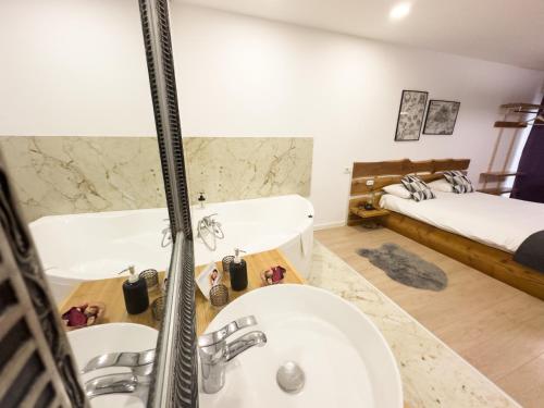 baño con lavabo, bañera y cama en MiddleHouse, en Brasov