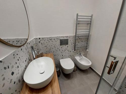 a bathroom with two toilets and a sink and a mirror at Studio Donatello in Milan