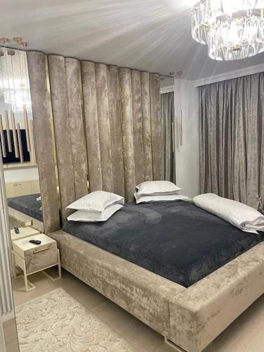Apartament Luxury Promenada في كرايوفا: غرفة نوم بسرير كبير مع نافذة كبيرة