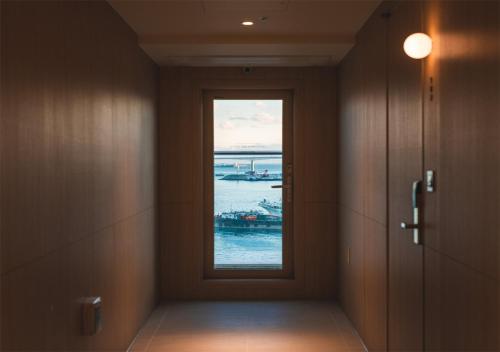 a hallway with a window looking out at the water at Nampo Ocean2Heaven Hotel& Spa in Busan