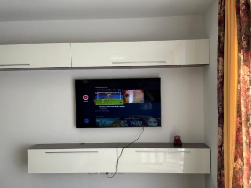 a flat screen tv hanging on a white wall at New, airy and spacious apartment in Mellieha in Mellieħa