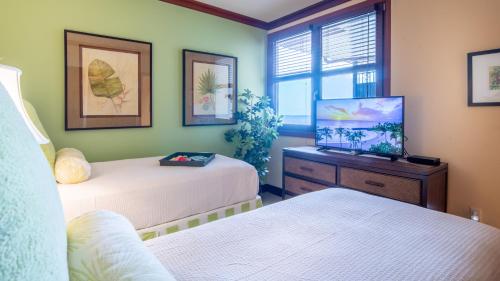 a room with two beds and a television in it at Ko Olina Beach Villas O1111 in Kapolei