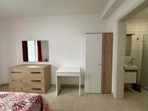 - une chambre avec un lit, une commode et un lavabo dans l'établissement New, airy and spacious apartment in Mellieha, à Mellieħa