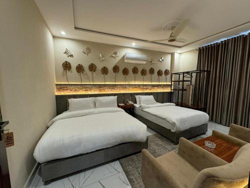 Shelton Boulevard Hotel Lahore في لاهور: غرفة فندقية بسريرين واريكة
