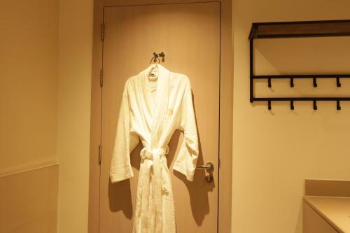 a white robe is hanging on a door at Twilight 1BR apartment Yas Island in Abu Dhabi