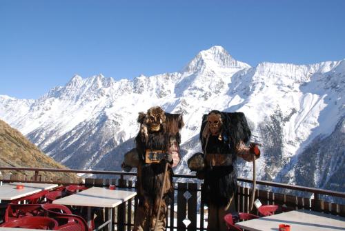 two people dressed in costumes standing in front of a mountain at Alpenhotel zur Wildi Lauchernalp in Wiler