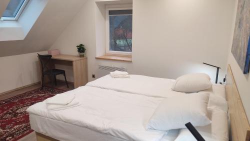 a white bed in a room with a window at Frejstejn House, Artist's Residence in Podhradí nad Dyjí