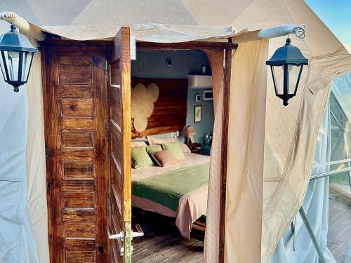 a bedroom with a canopy bed with a wooden dresser at Entre racimos, glamping entre viñedos in Ciudad Lujan de Cuyo