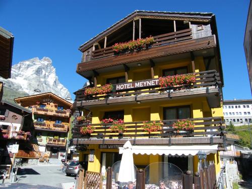 a hotel with flowers on the balconies of a building at Hotel Meynet in Breuil-Cervinia
