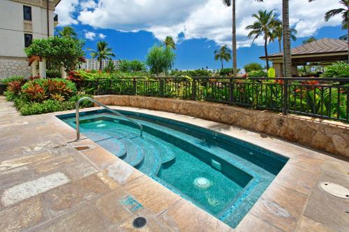a small swimming pool in a yard with a fence at Ko Olina Beach Villas O1402 in Kapolei