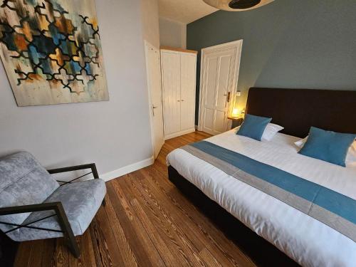 a bedroom with a bed and a chair in it at L'ALBIZIA in Libin