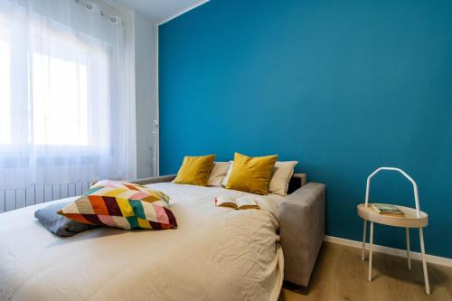 a bedroom with a large bed with a blue wall at Arona Centro - Blue Lake - Wi-Fi - AC in Arona