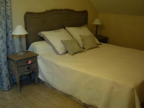 a bedroom with a large bed with white sheets and pillows at La Grange du Bourg in Deneuille-les-Mines