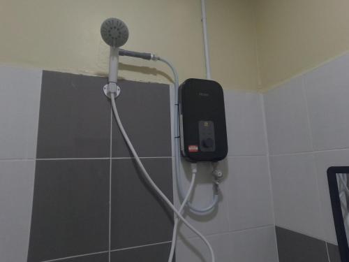 a shower in a bathroom with a phone on the wall at NURUL ROOMSTAY LANGKAWI in Pantai Cenang