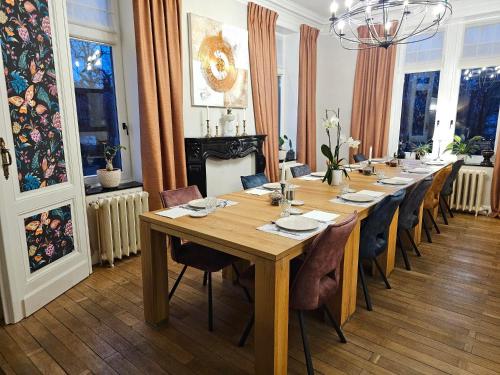 a dining room with a long table and chairs at L'ALBIZIA in Libin