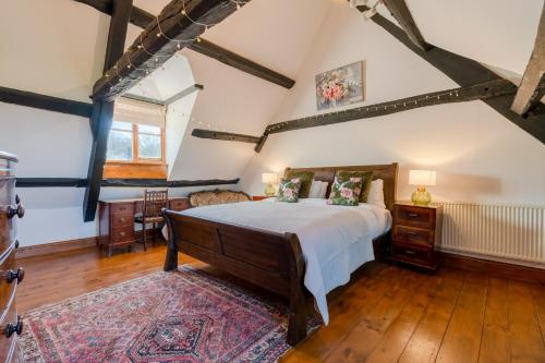 ein Schlafzimmer mit einem großen Bett im Dachgeschoss in der Unterkunft Canons Court Lodge in Wotton under Edge