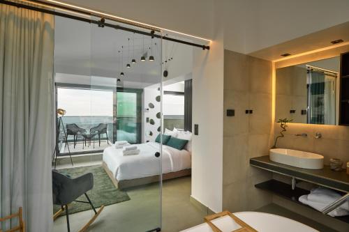 a bedroom with a bed and a bathroom at SIGMA Suites Hotel in Thessaloniki