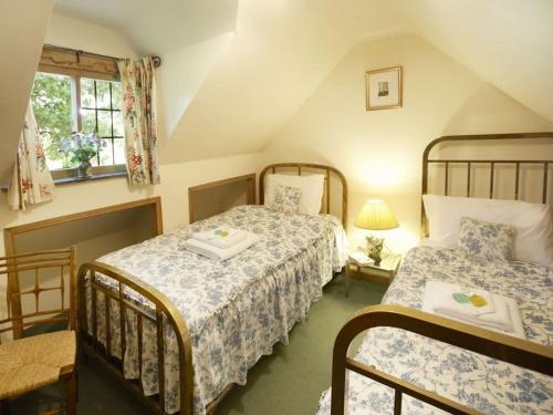 een slaapkamer met 2 bedden en een raam bij Long Cover Cottage in Tenbury