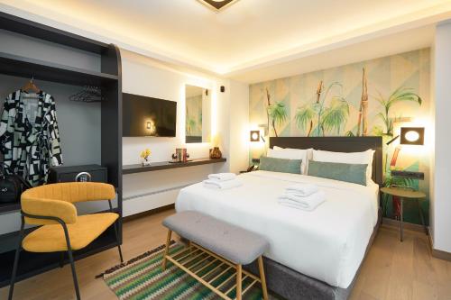 a bedroom with a large white bed and a chair at SIGMA Suites Hotel in Thessaloniki