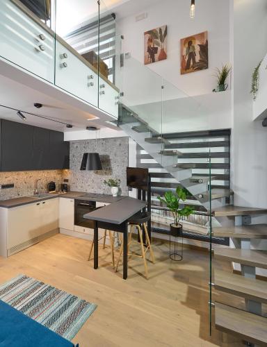 a kitchen and dining room with a staircase in a house at SIGMA Suites Hotel in Thessaloniki
