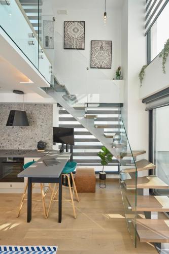 a glass staircase in a living room with a table at SIGMA Suites Hotel in Thessaloniki