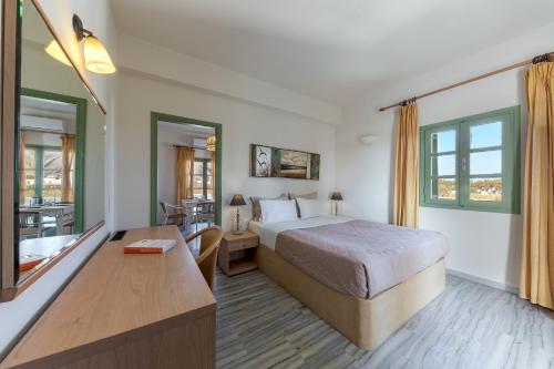 una camera d'albergo con letto e scrivania di Ambeli Apartments a Perivolos