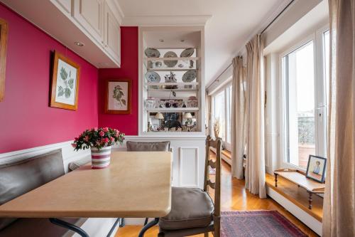 jadalnia z drewnianym stołem i różowymi ścianami w obiekcie Veeve - A Study in Pink w mieście Boulogne-Billancourt