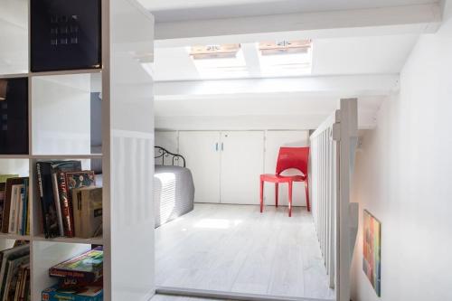 - un salon avec une chaise rouge et des étagères dans l'établissement Escapade Marine : Vue mer, 2 chambres, Parking, à pied de la plage, à Sainte-Maxime