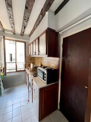 cocina con armarios de madera y microondas en Appartement en centre ville de Versailles, en Versalles