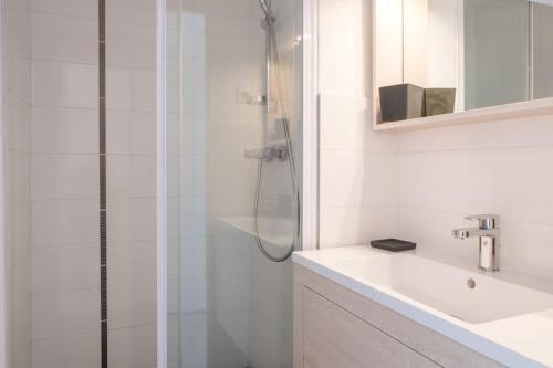 une salle de bain blanche avec une douche et un lavabo dans l'établissement Escapade Marine : Vue mer, 2 chambres, Parking, à pied de la plage, à Sainte-Maxime