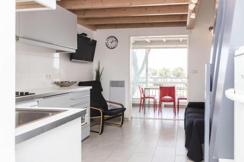 une cuisine avec des armoires blanches et une table avec des chaises dans l'établissement Escapade Marine : Vue mer, 2 chambres, Parking, à pied de la plage, à Sainte-Maxime