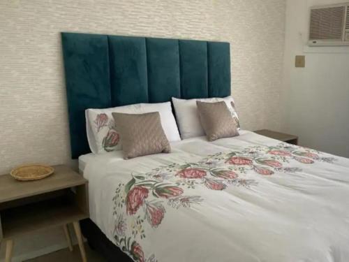 Schlafzimmer mit einem großen Bett mit einem grünen Kopfteil in der Unterkunft Modern Executive Stay in Upington