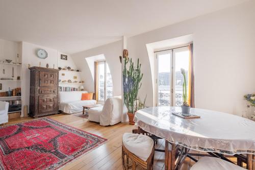 un salon blanc avec une table et des chaises dans l'établissement Veeve - Theatre in the Sky, à Paris