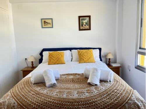 a bedroom with a large bed with yellow pillows at Santa Ana in Denia
