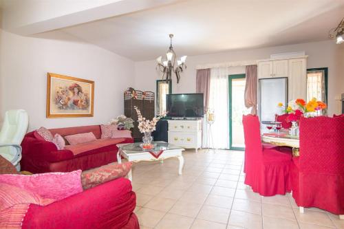a living room with red couches and a table at Marathi Apartments in Marathi
