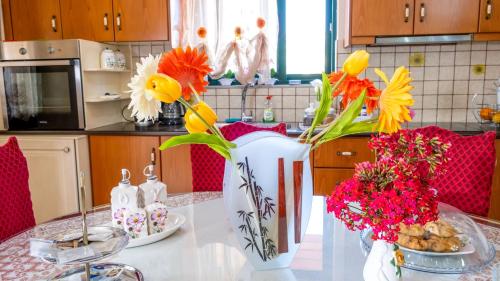a kitchen with a table with flowers in a vase at Marathi Apartments in Marathi