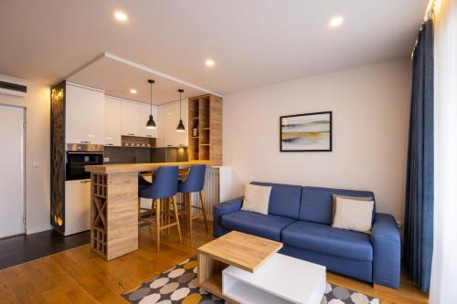 a living room with a blue couch and a kitchen at Vip Casa Club Zlatibor in Zlatibor