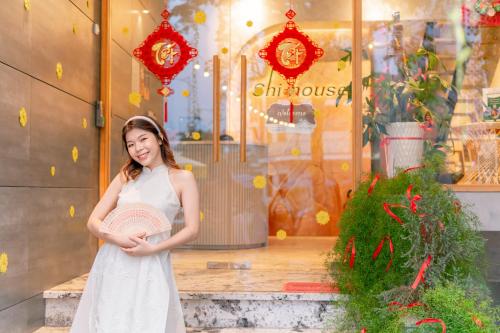 峴港的住宿－SHI HOUSE by Haviland，站在商店前身穿白色衣服的女孩