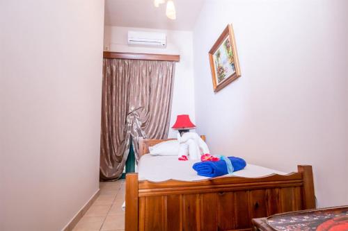 a bed with a stuffed animal with a red hat on it at Marathi Apartments in Marathi