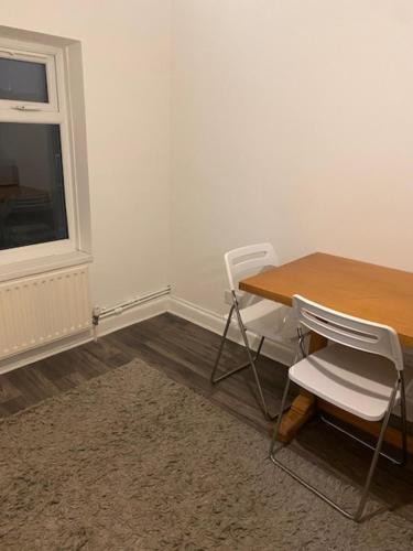 a table and chairs in a room with a window at Circle Guest House Bed Only in Southampton