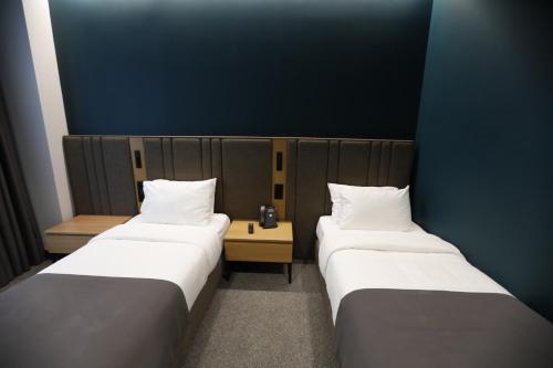 two beds in a room with blue walls at Graf Hotel in Tbilisi City