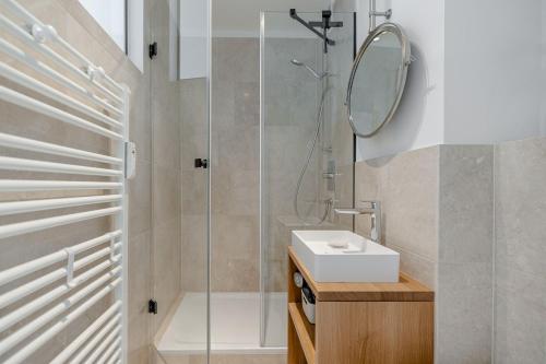 a bathroom with a shower and a sink and a mirror at App Nordseeperle in List