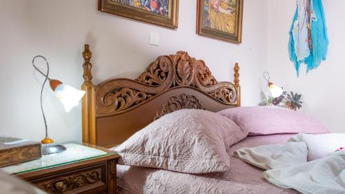 a bed with a wooden headboard next to a table at Marathi Apartments in Marathi