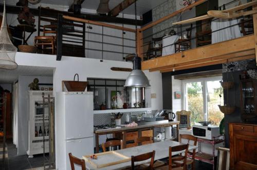 a kitchen with a white refrigerator and a table and chairs at Loge & Broc in La Possonnière